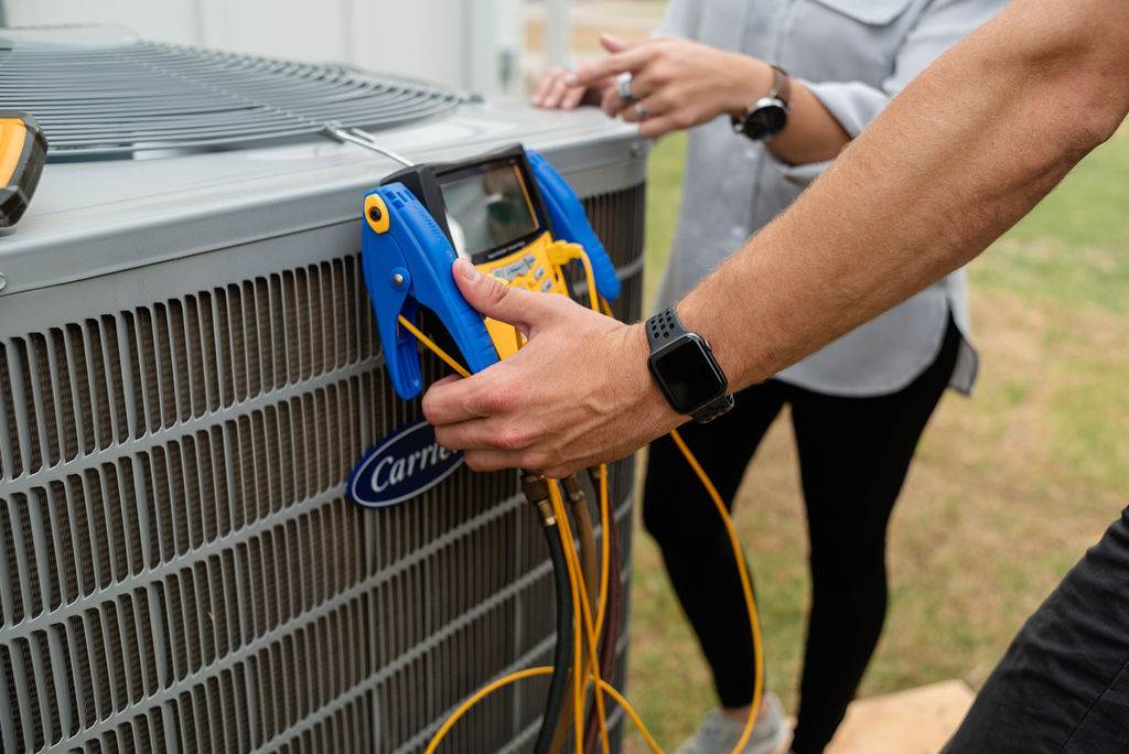 Technician testing an outdoor AC unit