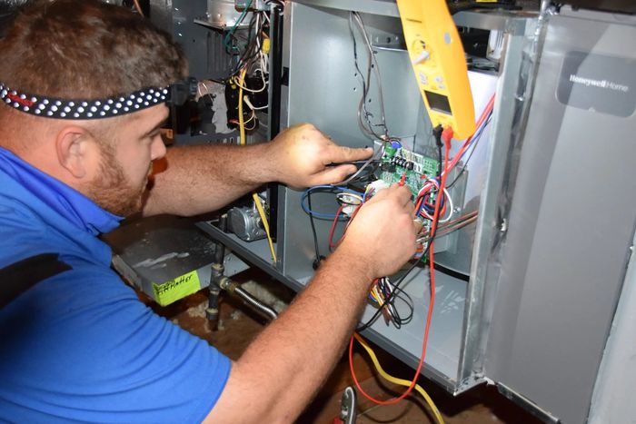 Technician repairing a home heating system.