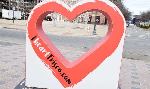 Heart-shaped fixture at intersection of streets, with "iheartfrisco.com" along one side of the heart.