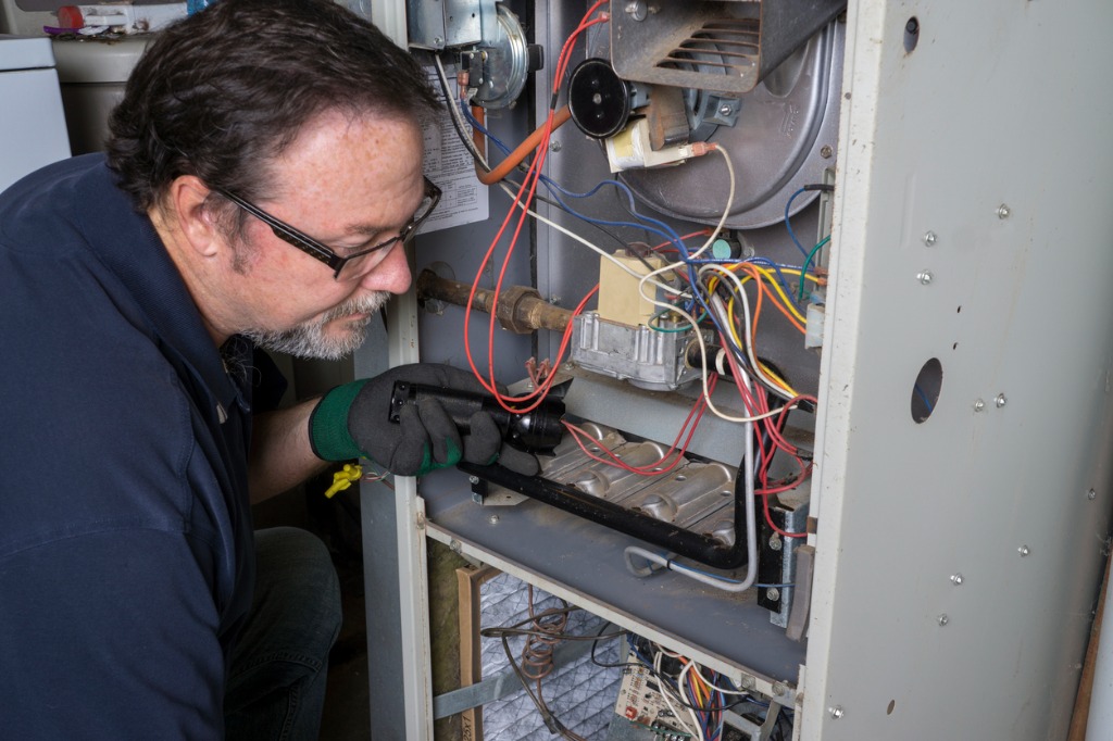 Technician installing a furnace in a home.